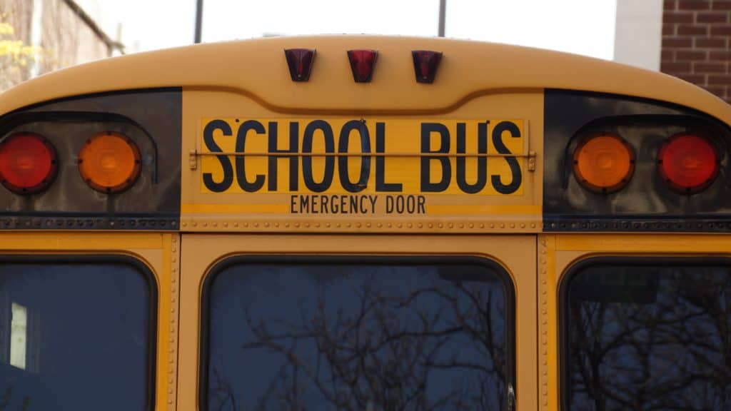 School bus close-up with yellow and black colors, emphasizing safe transportation for students or clients.