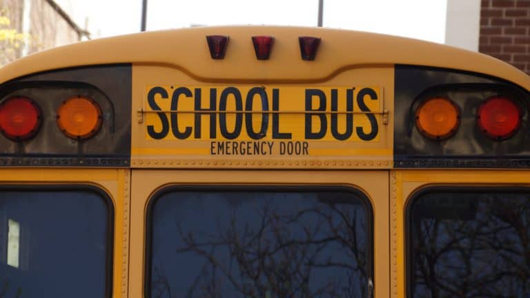 School bus close-up with yellow and black colors, emphasizing safe transportation for students or clients.