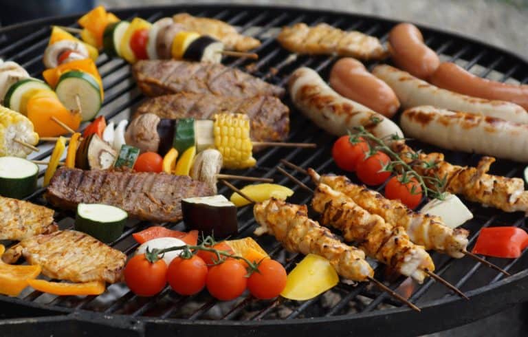 Delicious grilled vegetables, meats, and chicken skewers on a barbecue grill, emphasizing healthy outdoor cooking and nutrition.