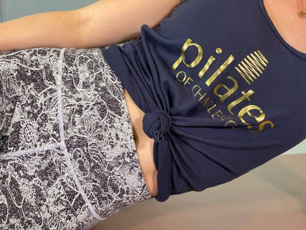 Comfortable casual workout outfit featuring Pilates of Charleston logo top and patterned leggings.