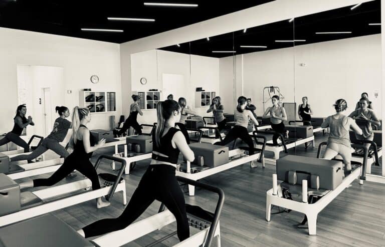 Pilates reformer workout in Charleston, SC, with women practicing core exercises in a modern studio.