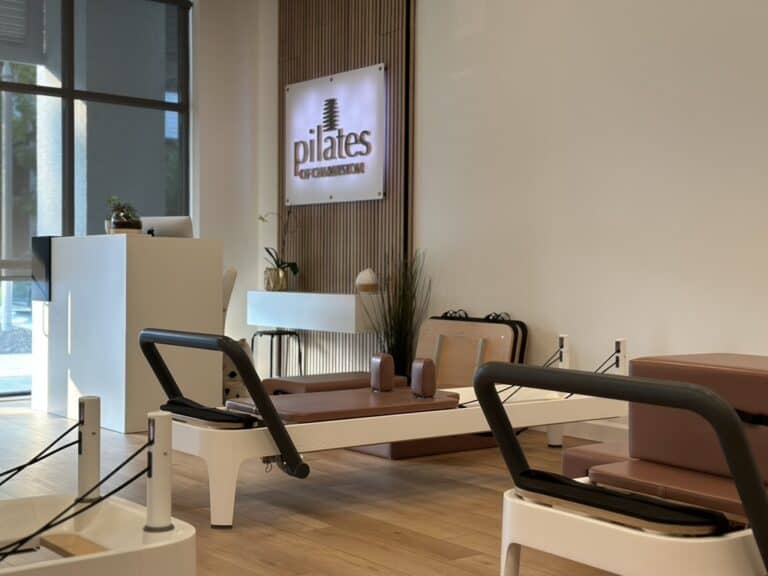 Modern Pilates studio interior with reformer machines and natural light.
