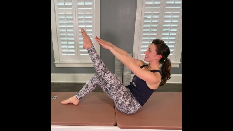 Woman doing Pilates on mat with leg reach exercise in Charleston.