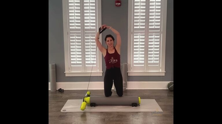 Woman demonstrating use of Pilates roller and resistance bands at Pilates of Charleston.