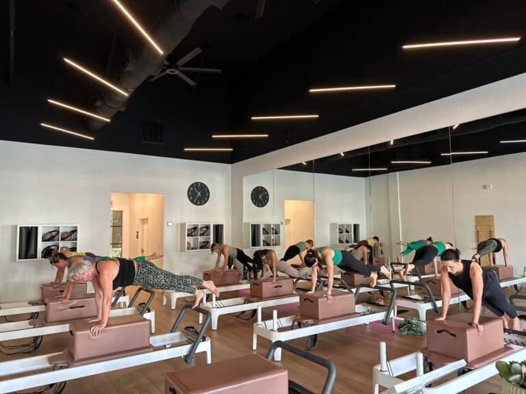 A group Pilates class at Charleston studio using reformer machines for fitness and core strength.