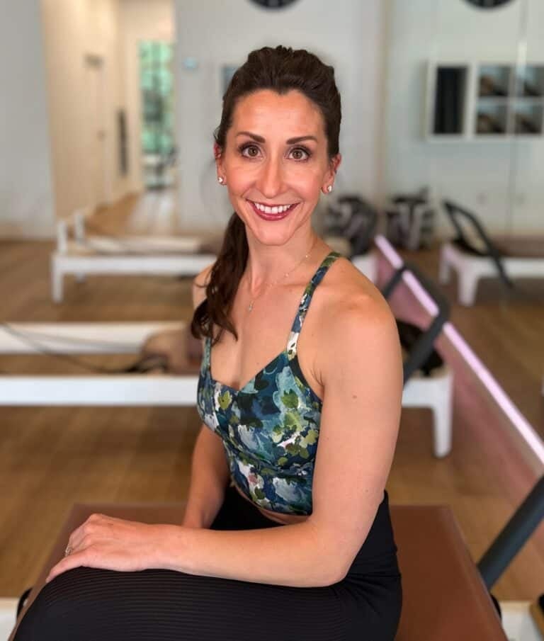 Bright, friendly Pilates studio with instructor, mats, and equipment for healthy fitness.