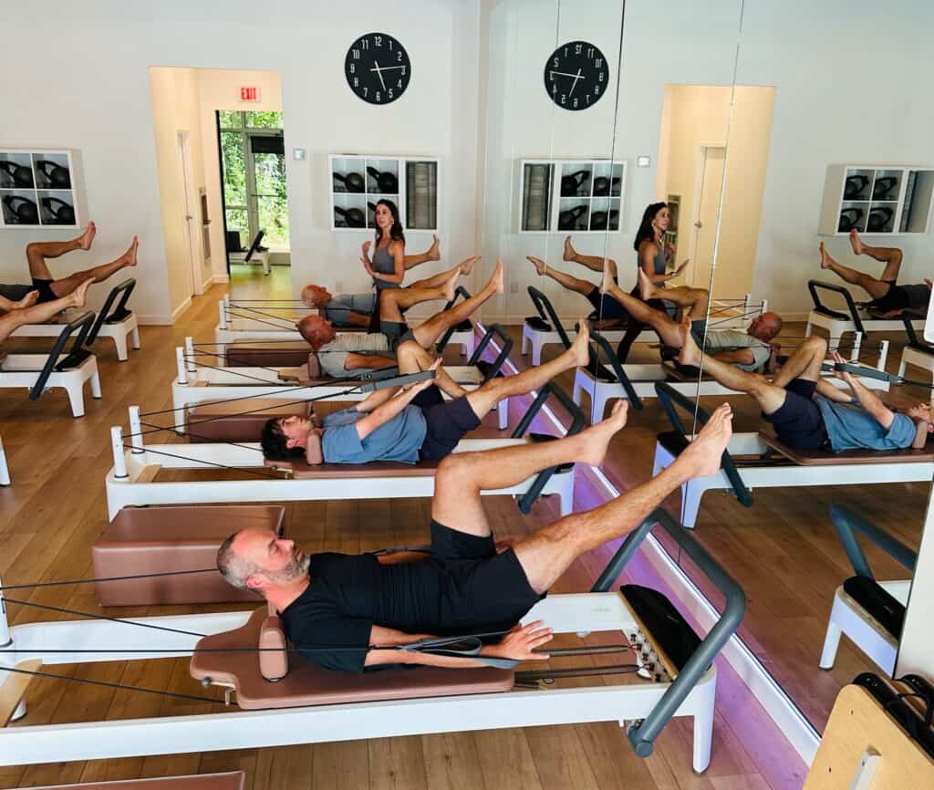 Pilates reformer workout session with people in a Charleston fitness studio.