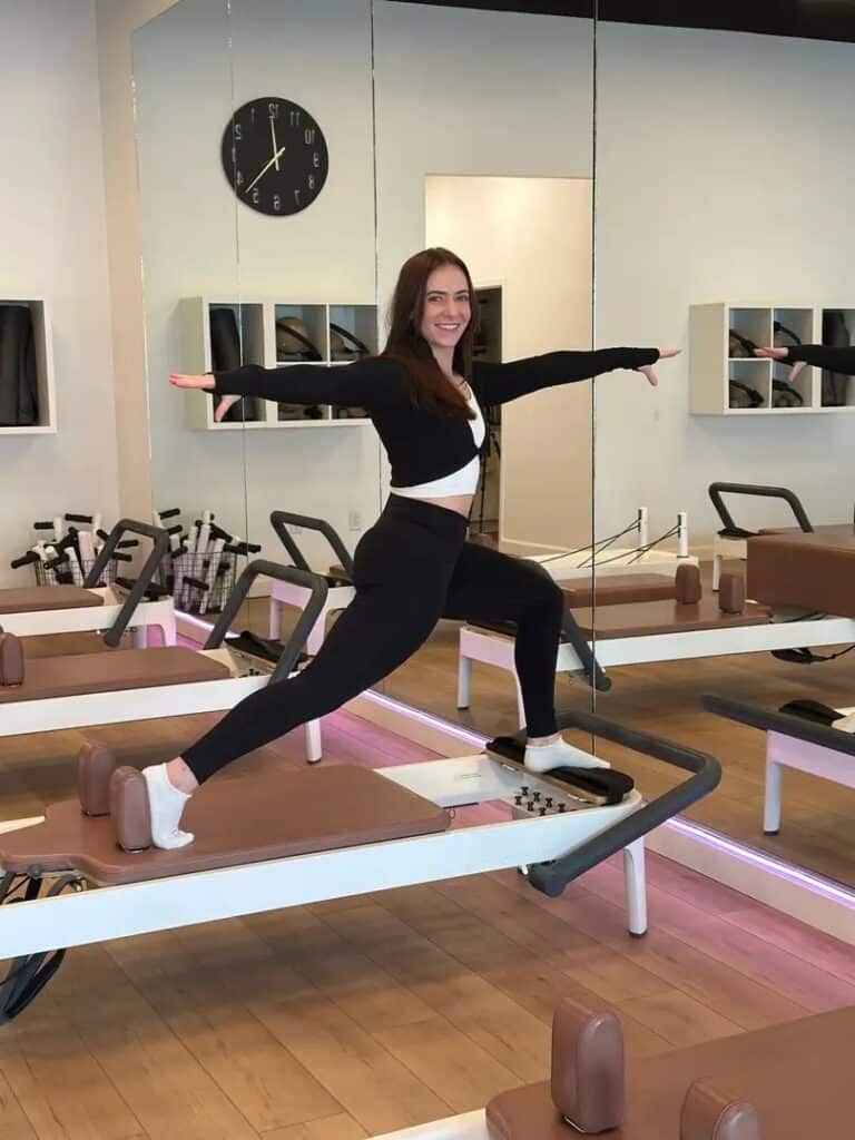 Client working one on one with an instructor in a private reformer Pilates session